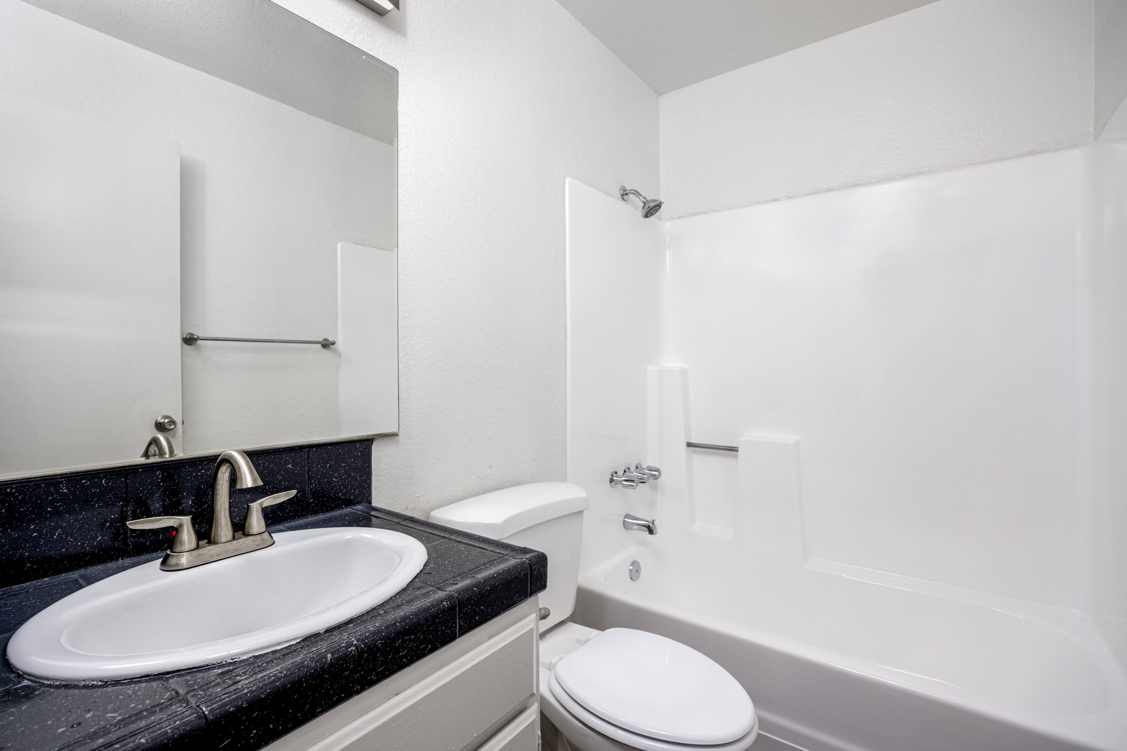 A white toilet sits next to a sink in a bathroom.